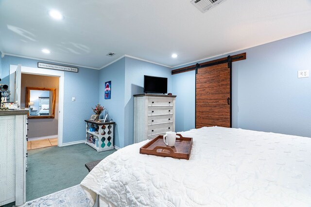 bedroom featuring a barn door, ornamental molding, and carpet floors