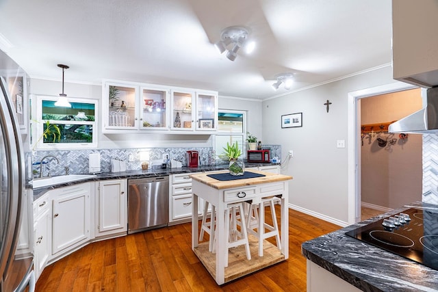 kitchen featuring dark wood-type flooring, white cabinetry, appliances with stainless steel finishes, and hanging light fixtures