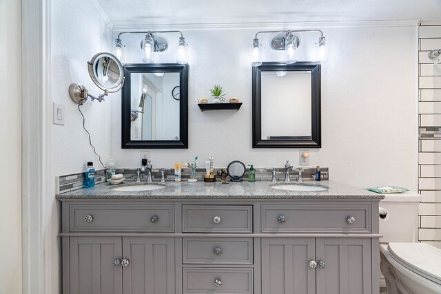 bathroom with crown molding, vanity, and toilet