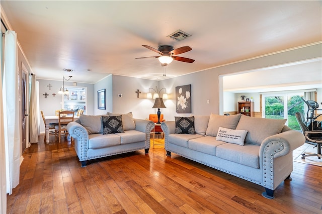 living room featuring dark hardwood / wood-style flooring, ceiling fan, and crown molding