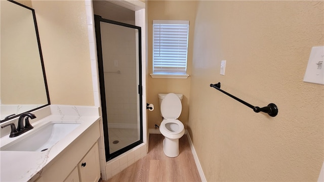 bathroom with toilet, vanity, hardwood / wood-style flooring, and walk in shower