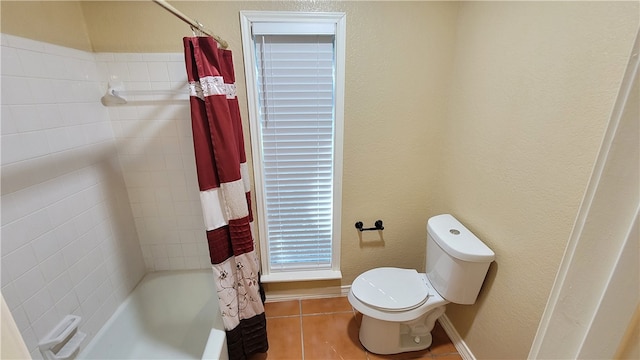 bathroom featuring tile patterned flooring, shower / bath combo, and toilet