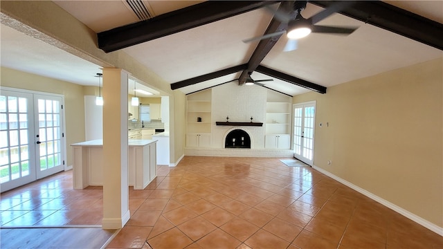 unfurnished living room with a brick fireplace, french doors, light tile patterned floors, ceiling fan, and built in features