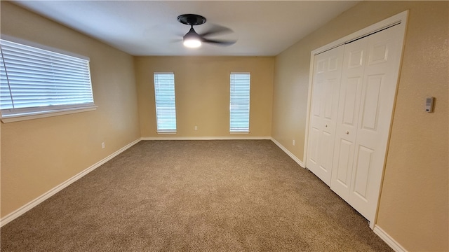 unfurnished bedroom featuring carpet, ceiling fan, and a closet