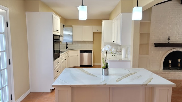 kitchen with pendant lighting, stainless steel dishwasher, oven, and white cabinets