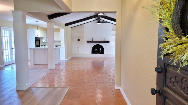 foyer entrance featuring vaulted ceiling with beams, ceiling fan, and light tile patterned flooring