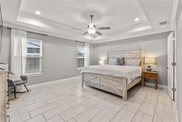 bedroom featuring ceiling fan, a tray ceiling, and ornamental molding