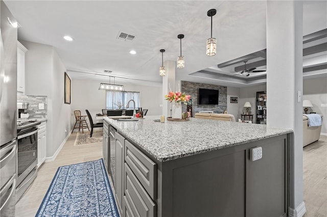 kitchen featuring sink, ceiling fan, appliances with stainless steel finishes, a kitchen island with sink, and gray cabinetry