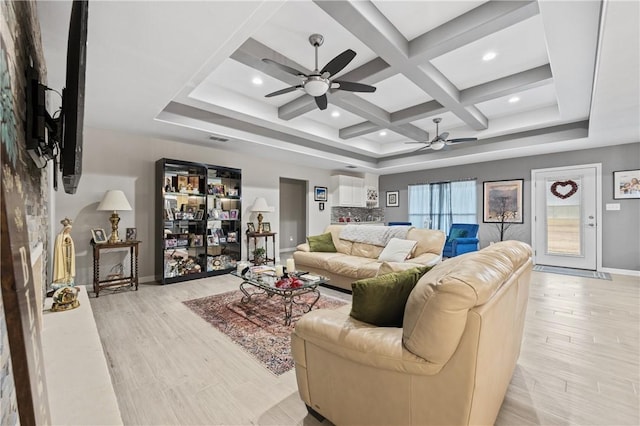 living room with coffered ceiling, beam ceiling, ceiling fan, and light wood-type flooring