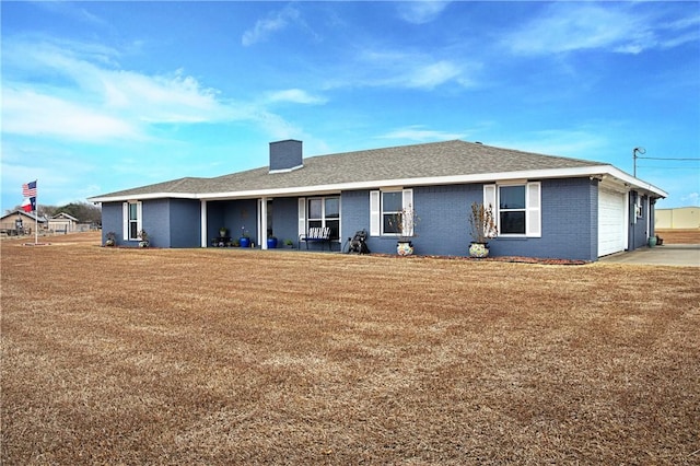 back of property with a garage and a lawn