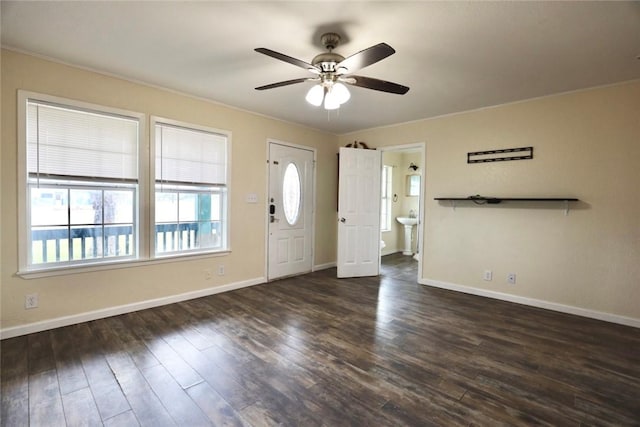 foyer entrance featuring ceiling fan, sink, dark wood-type flooring, and crown molding