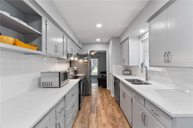 3818 Kingston Dr, Corpus Christi, TX 78415 - kitchen with appliances with stainless steel finishes, light wood finished floors, recessed lighting, decorative backsplash, and light countertops