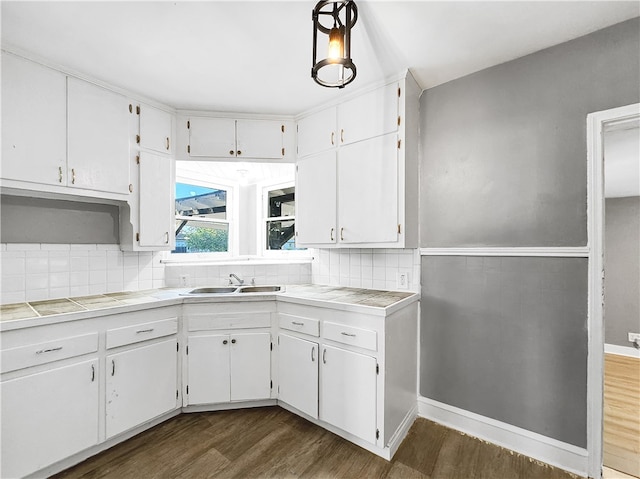 kitchen with tile countertops, white cabinetry, sink, and dark wood-type flooring