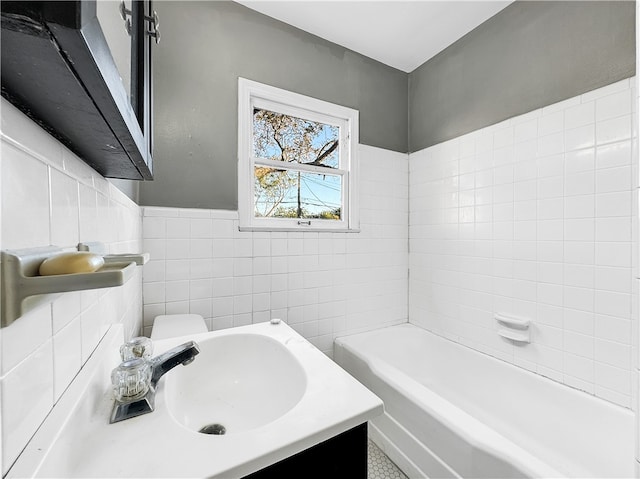 bathroom with a tub to relax in, sink, and tile walls