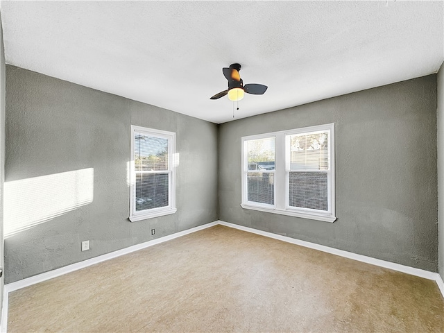 unfurnished room with a textured ceiling, carpet floors, plenty of natural light, and ceiling fan