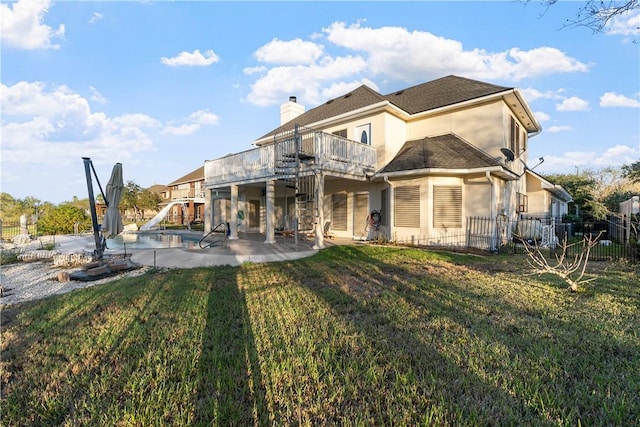 rear view of property featuring a patio area, a yard, and a deck