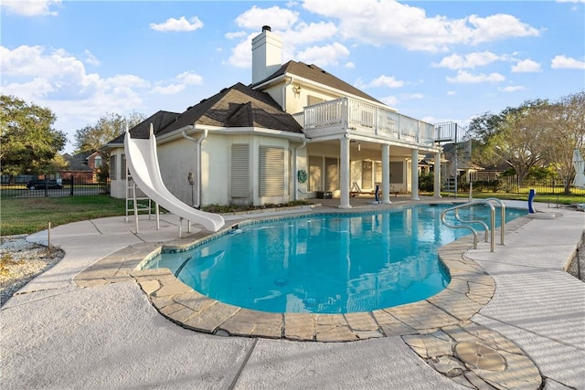 view of swimming pool with a patio area and a water slide