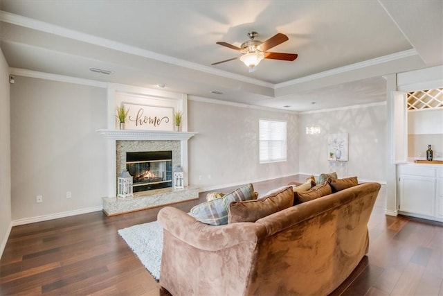 7421 Blue Lake Dr, Corpus Christi, TX 78413 - living area featuring dark wood-style floors, ceiling fan, a fireplace, a tray ceiling, and crown molding