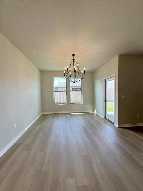 2605 Las Estrellas St, Corpus Christi, TX 78414 - unfurnished room featuring a chandelier, wood finished floors, healthy amount of natural light, and baseboards