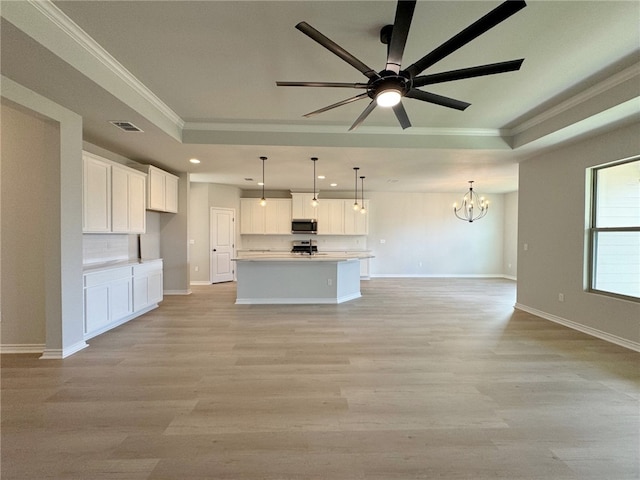 kitchen with white cabinetry, hanging light fixtures, stainless steel appliances, light hardwood / wood-style flooring, and a center island with sink