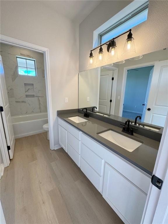 2605 Las Estrellas St, Corpus Christi, TX 78414 - bathroom featuring double vanity, wood finished floors, toilet, and shower / bath combination