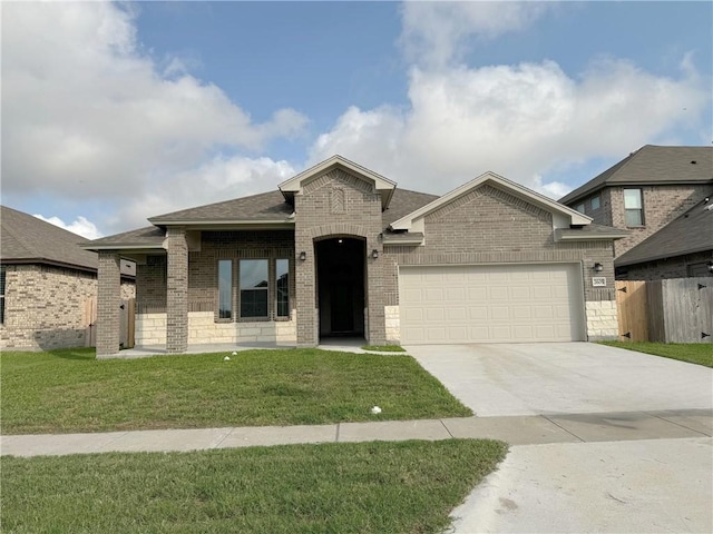 2605 Las Estrellas St, Corpus Christi, TX 78414 - french country home with brick siding, an attached garage, concrete driveway, and roof with shingles