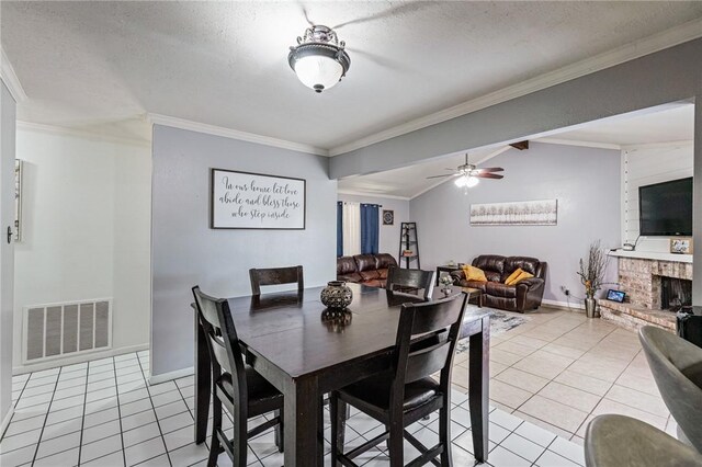 11805 Night Hawk, Corpus Christi, TX 78410 - dining space with light tile patterned floors, crown molding, baseboards, ceiling fan, and a brick fireplace