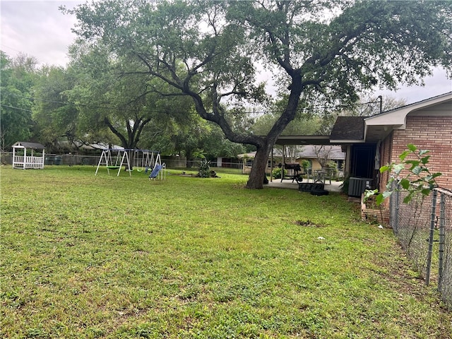 view of yard featuring a playground, a patio, and central AC