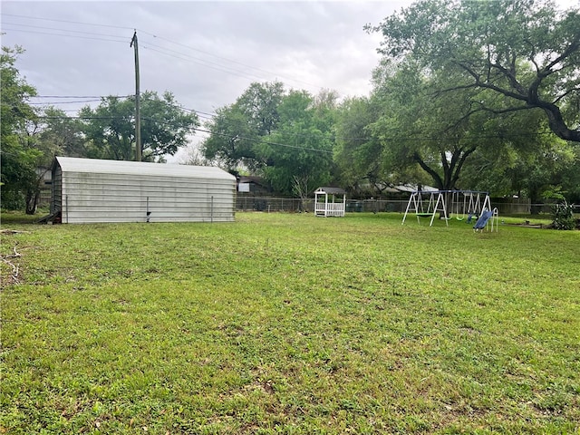 view of yard featuring a storage unit and a playground