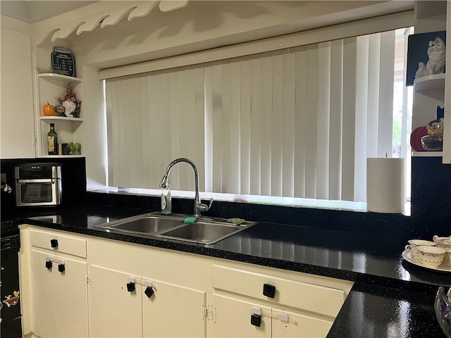 kitchen featuring white cabinets, sink, and backsplash