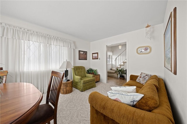 carpeted living room featuring stairs