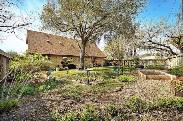 view of yard featuring a fenced backyard and a vegetable garden