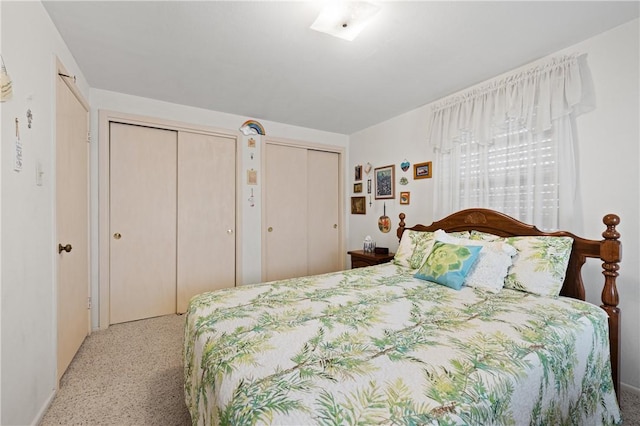 bedroom featuring speckled floor and multiple closets