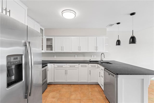 kitchen with a sink, a peninsula, stainless steel appliances, visible vents, and white cabinets