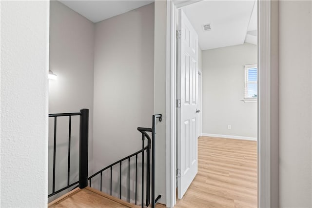 stairway featuring visible vents, wood finished floors, and baseboards