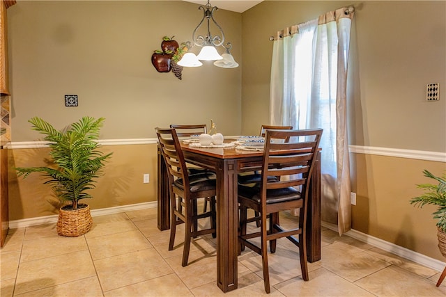 tiled dining area with a chandelier