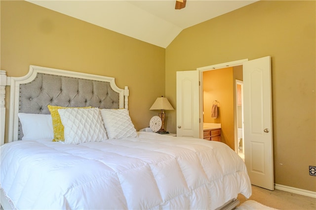 bedroom with ceiling fan, connected bathroom, light carpet, and lofted ceiling