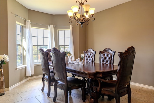 tiled dining room with a chandelier