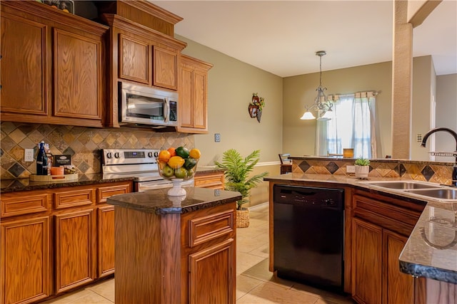 kitchen featuring sink, appliances with stainless steel finishes, tasteful backsplash, light tile patterned floors, and a kitchen island