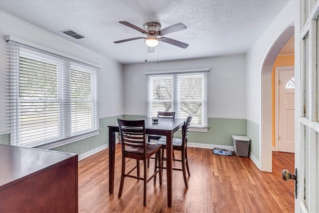 dining area with ceiling fan, a healthy amount of sunlight, a textured ceiling, and light hardwood / wood-style flooring