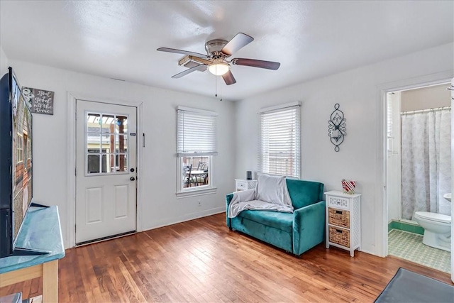 sitting room with hardwood / wood-style floors and ceiling fan