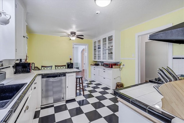 kitchen with dishwasher, stove, range hood, tile counters, and white cabinetry