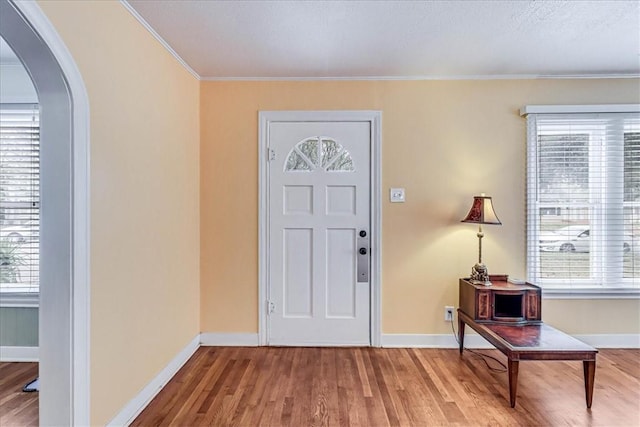 entryway featuring wood-type flooring and ornamental molding