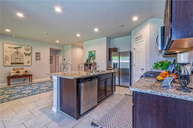 3922 Jayden Dr, Corpus Christi, TX 78410 - kitchen featuring appliances with stainless steel finishes, a kitchen island with sink, light stone counters, recessed lighting, and dark brown cabinets