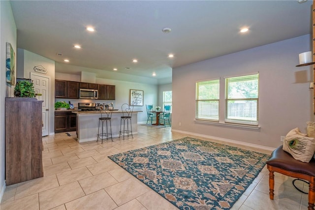 3922 Jayden Dr, Corpus Christi, TX 78410 - kitchen with stainless steel appliances, recessed lighting, dark brown cabinetry, open floor plan, and light tile patterned flooring