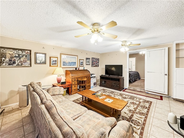 living room with ceiling fan, light tile patterned floors, and a textured ceiling