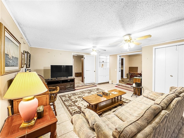 living room with a textured ceiling, ceiling fan, and light tile patterned floors