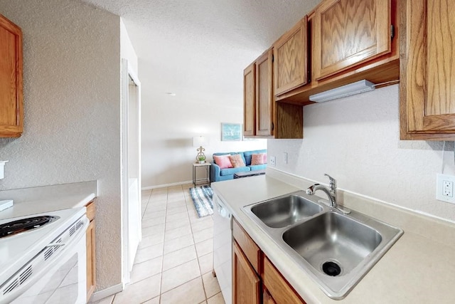 kitchen featuring a textured ceiling, white appliances, sink, and light tile patterned floors