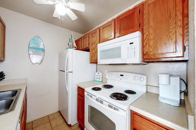 kitchen with white appliances, sink, ceiling fan, light tile patterned floors, and a textured ceiling