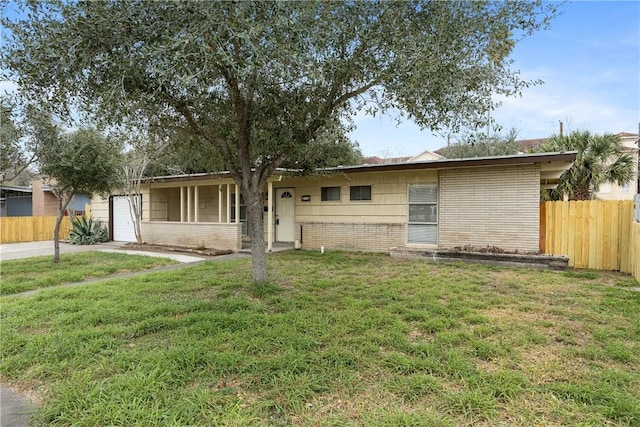 ranch-style home featuring an attached garage, brick siding, a front yard, and fence